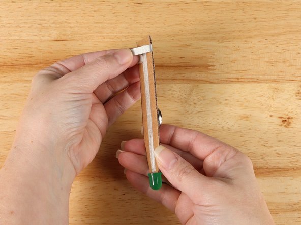 The strip of tape should NOT touch the path of Maker Tape on the back of the handle, but it SHOULD overlap with the piece of Maker Tape on the front side of the handle.