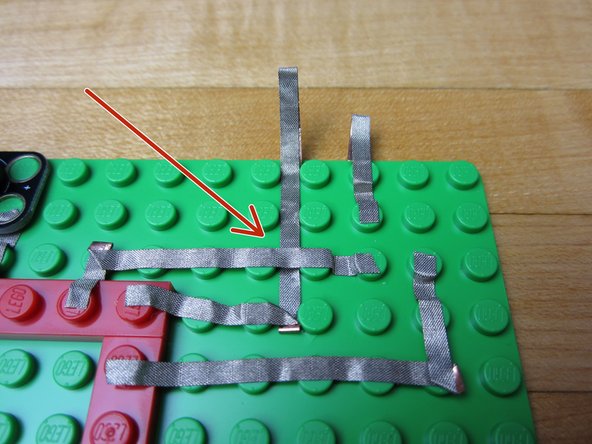 Use a longer line of tape and go from the Ground pin off the side of the board.