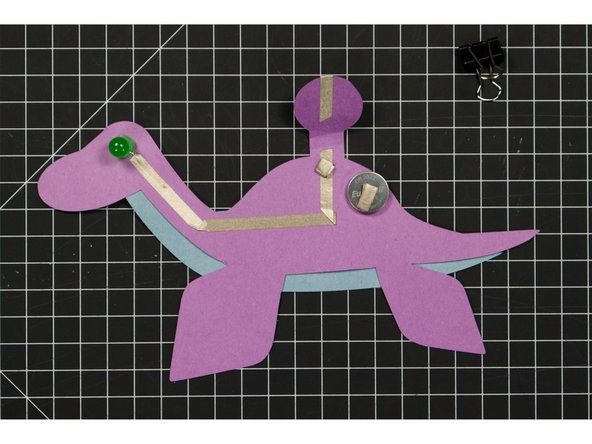 Since Maker Tape is conductive on both sides you can use it to make a tape loop that helps hold your battery in place.