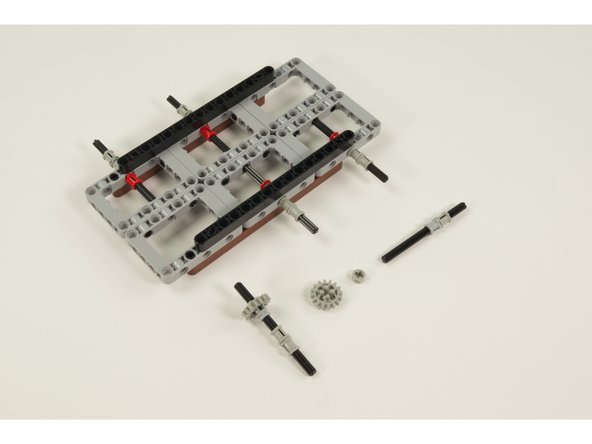 The last two axles will be used to drive the vehicle, so we need to add a LEGO Gear with 16 Teeth Unreinforced  along with a  LEGO Half Bushing.