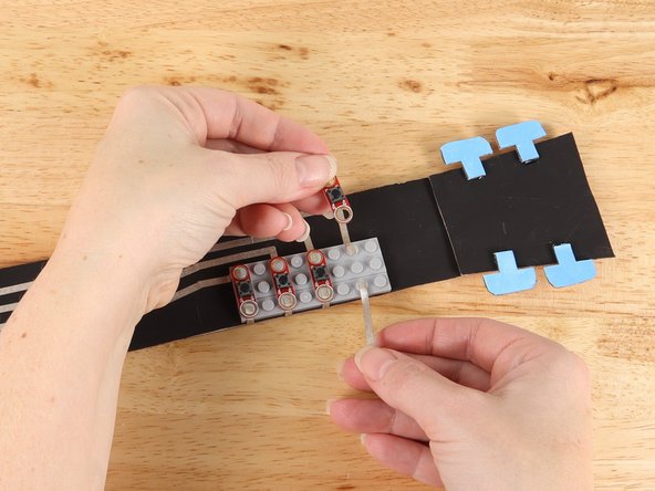 Remove the fourth button and add a piece of Maker Tape to the bottom stud as pictured.