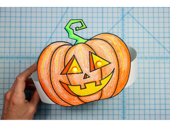 Cut out the side strips and tape them to the hat with the slits facing up on one side and down on the other. 