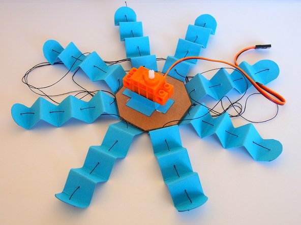 Glue the servo holder to the cardboard base of the Octobot