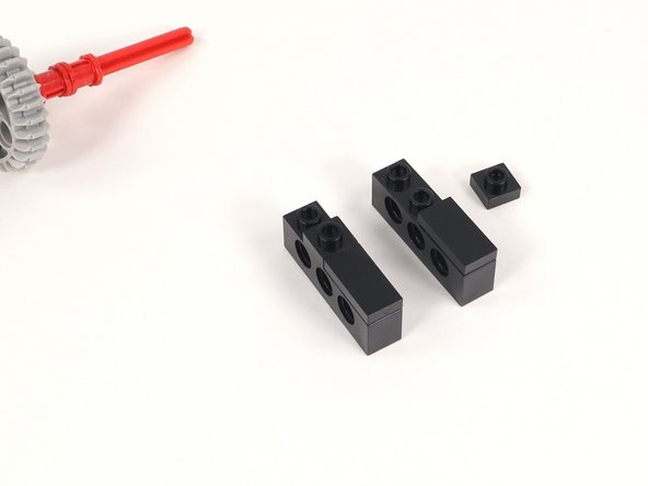 Add a 1x1 plate to each 1x4 brick with holes adjacent to the 1x2 plate added in the previous step.