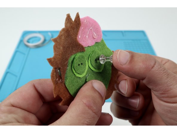 Once the glue has been allowed to cool, use a pushpin to poke two pairs of two holes side by side where you'd like the eyes to go.