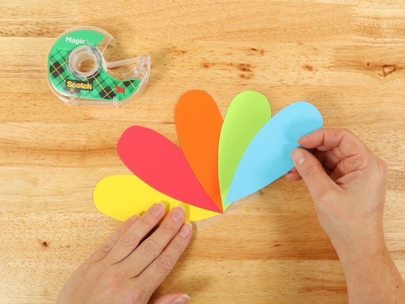 Using a piece of clear tape, line up the feathers with the points touching and tape them together.