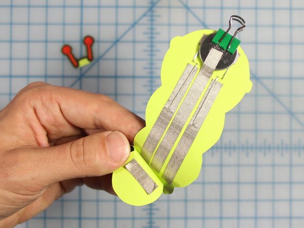 Fold the bottom of the worm so that the bottom most circle meets the three lines of Maker Tape.