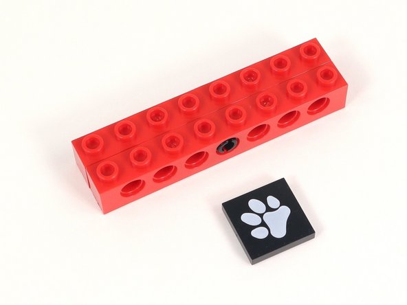 Add the 2x2 tile with a paw print to the middle four studs of the build.
