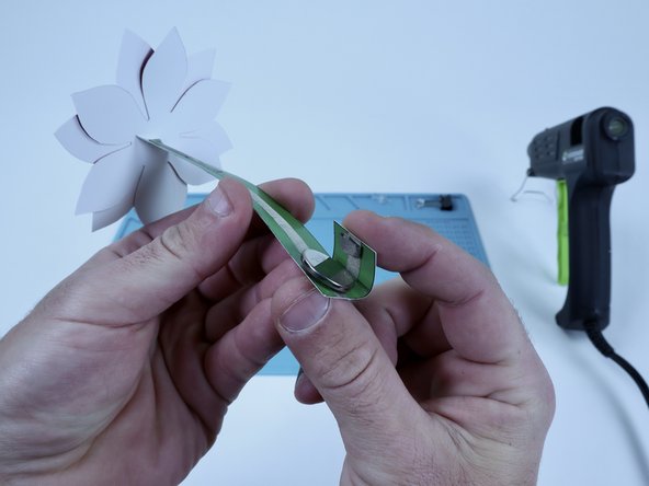 Fold tab over to stick that newest tape loop to the top of the battery. This should turn your circuit on. If it doesn't turn on, it's likely that you have the LED legs flipped. Rather than redoing those connections, you CAN just flip the battery around and it should work.