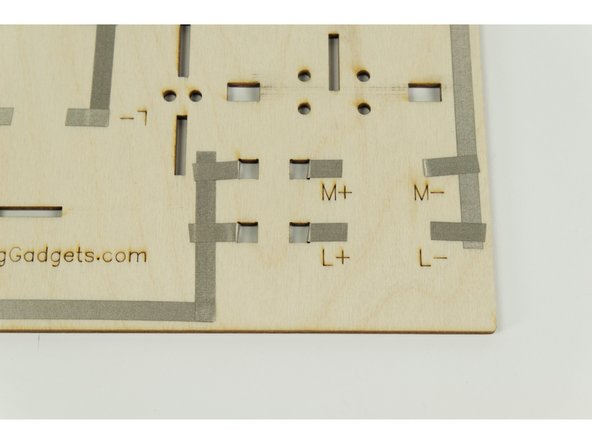 There are four square holes in the base that you'll need to push the Maker Tape through.