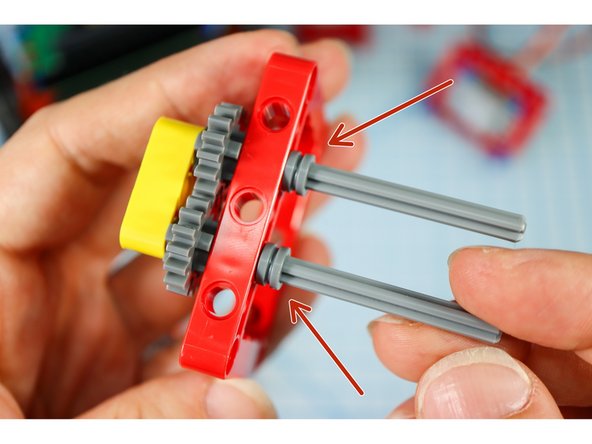Insert the axles into the second red frame, and secure with two half bushings.