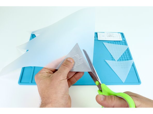 Find your sheet of velum, tracing paper or copy paper and use the gray triangle to help you cut 3 of the same shape with a scissors as shown.