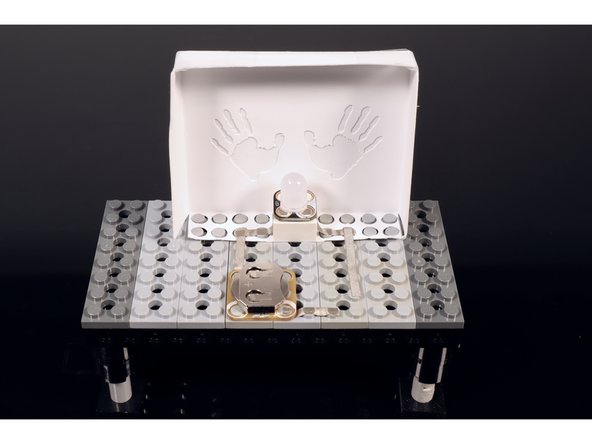 Now, press a single Crazy Circuits color-cycling LED into place atop the 2x2 LEGO brick. Again, take care to orient the part so that it matches the circuit diagram.