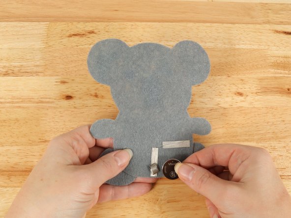 Make sure the Positive side of the Battery is facing upwards, with the Negative side stuck down to the tape.