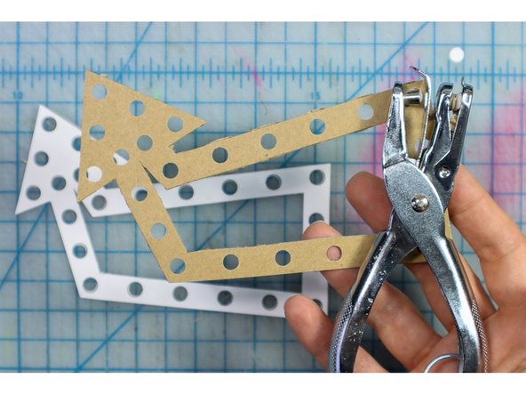 Cut out the arrow shape and use a hole punch to punch out the holes.