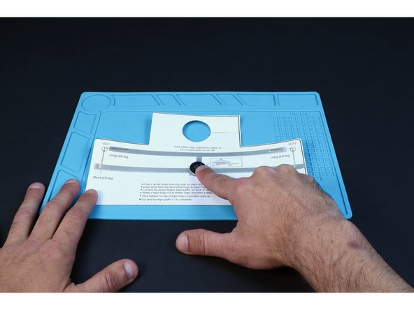 Stick the battery atop the tape loop with the positive (+) side facing UP.