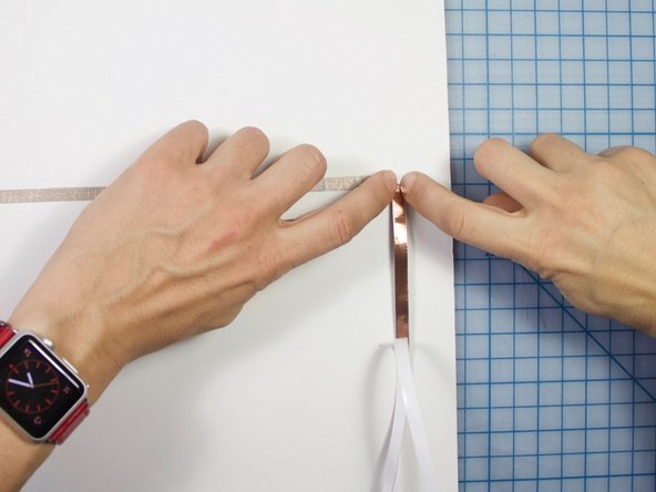 Starting above the battery, tape the battery to the poster board as shown.