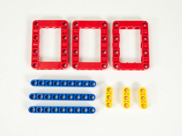 We'll start with 3 red frames, 3 blue 9 hole beams, 3 yellow 3 hole beams, and 12 black pins. (Not shown)