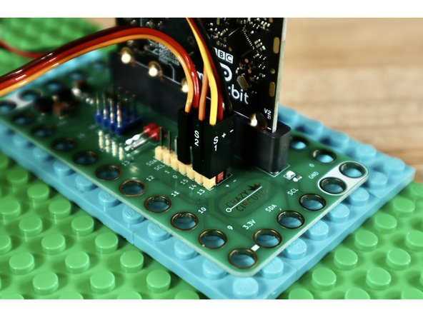 Use the banded Crazy Circuits ribbon cable to connect the distance sensor to the Bit Board. Slide 2 shows which cables go to which pins on the sensor. Slide 3 shows which cables go to which pins on the Bit Board.