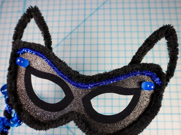 Make two triangles with another piece of pipe cleaner to make the ears and glue them in place.