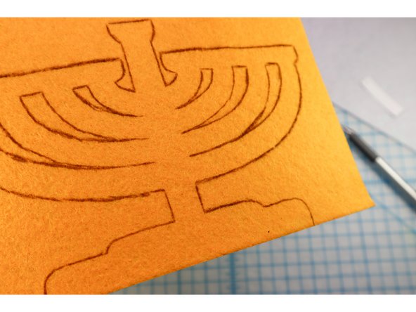 Trace the menorah shape onto the backside of the gold felt.