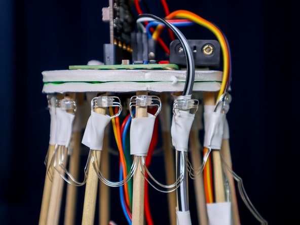 Tape an LED to each dowel, then move to the next one horizontally to make a full ring, then jump down to the next row and go around again until you've placed all 98 pixels.