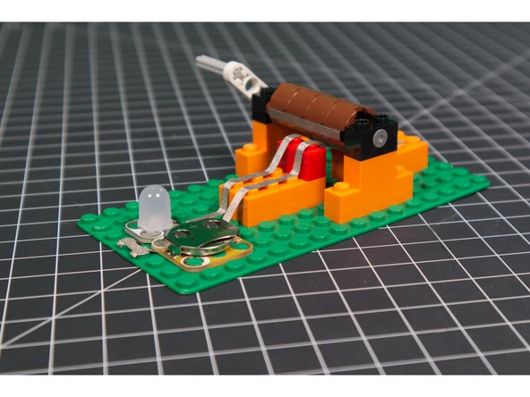 If it works, the cylinder will turn until the tape attached to it completes the circuit and the LED will turn on.