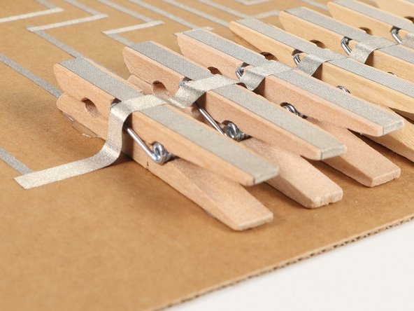 Attach the clothespins to the board in a row. Hot glue works well to hold them down.