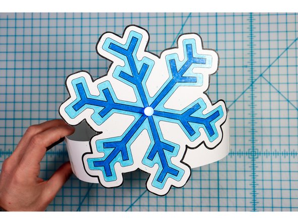 Cut out the side strips and tape them to the hat with the slits facing up on one side and down on the other.