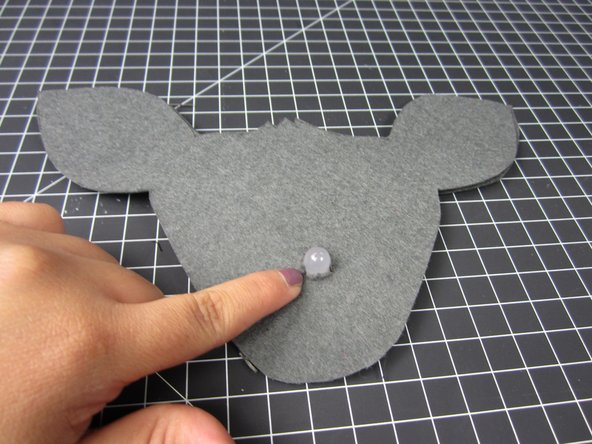 Use hot glue, fabric glue, or sew the second layer of face onto the electronics layer.