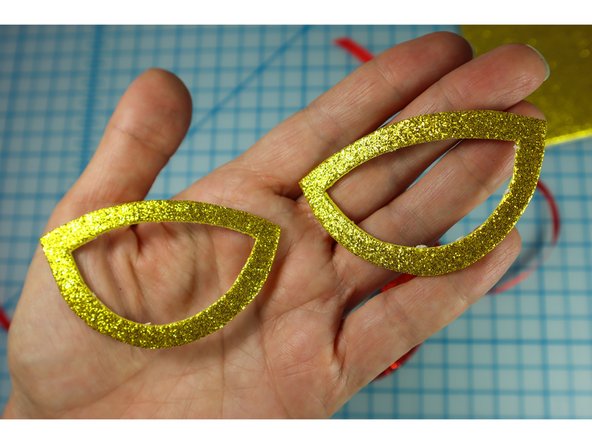 Glue the shapes around the eyes.
