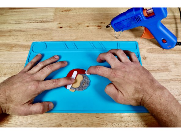 Press the furry pom pom detail piece into place atop the hot glue.