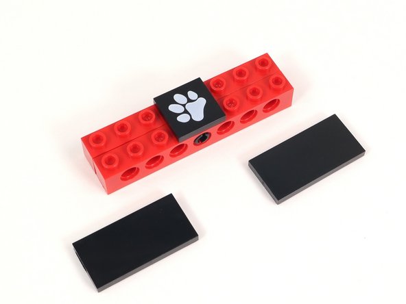 Add a 2x4 tile on either side of the paw print tile. Each of those tiles should hang off the build by one column of studs.