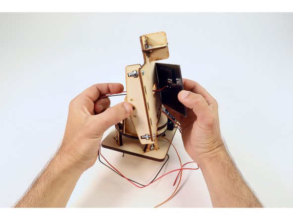 Pull the wires the rest of the way through and press the Solar Panel in place atop the mounting plate as shown.