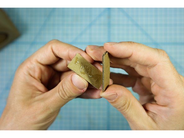 Glue 2 of the small rectangles together to make a thick button. Repeat two more times until you have three buttons.