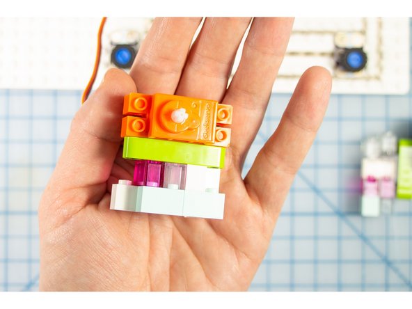 Stack a tower of bricks and connect the beam to the top of it.