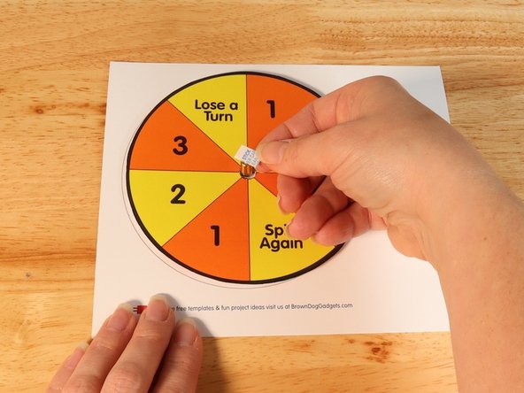 Add another square of double-sided tape onto the shaft of the motor, and then stick the arrow to it.