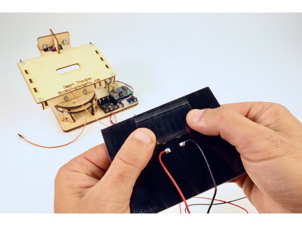 Leaving the opposite side backing intact, press the velcro in place as shown on the back side of the solar panel.