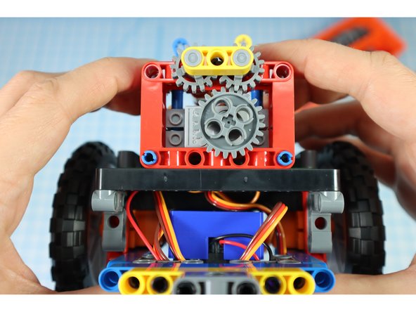 Add the arm gear assembly to the pins as shown.