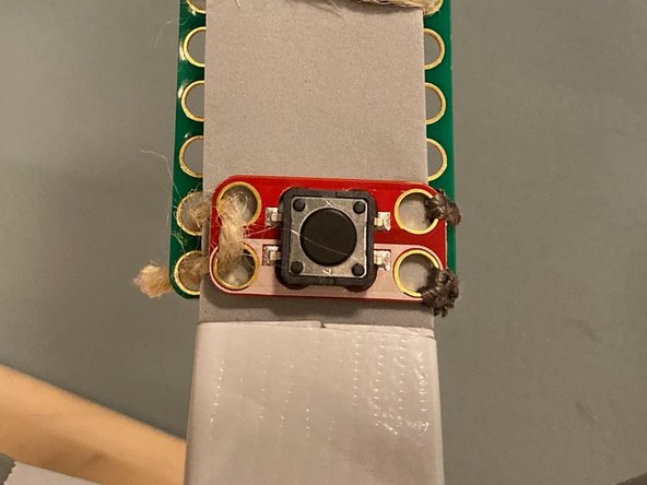 Using a new piece of conductive thread, connect the ground pin to the ground pin of the button.