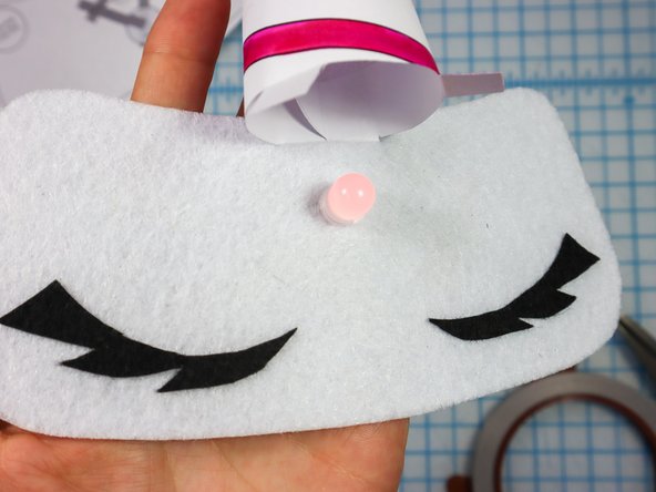 Insert the wide flap through the top slit, and the smaller flaps through the bottom two slits.