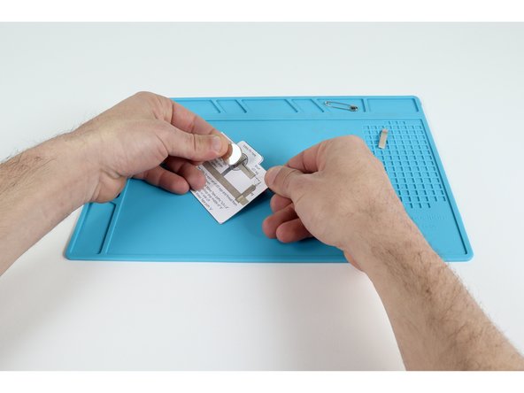 Stick battery atop the tape loop with the "+" side facing up.