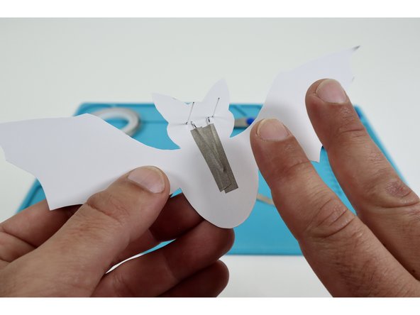 Peel and stick one of your three Maker Tape pieces atop one of the long legs and onto the paper below it.