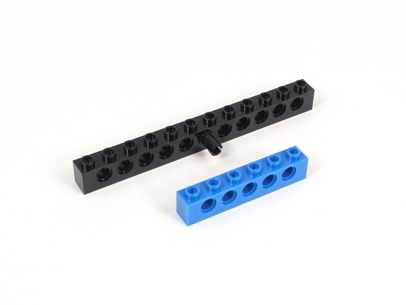 Connect the black pin through the middle hole of a 1x6 brick with holes.