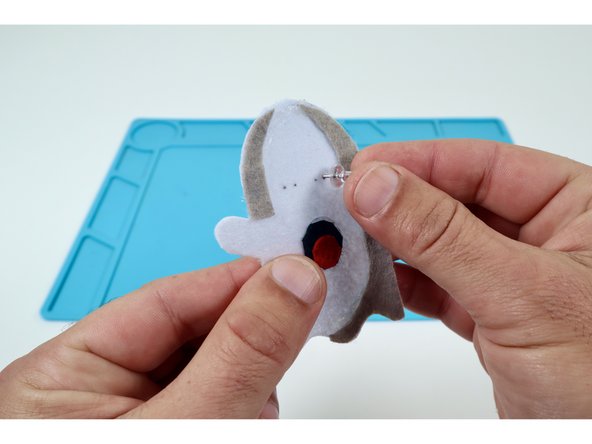 Once the glue has been allowed to cool, use a pushpin to poke two pairs of two holes side by side where you'd like the eyes to go.