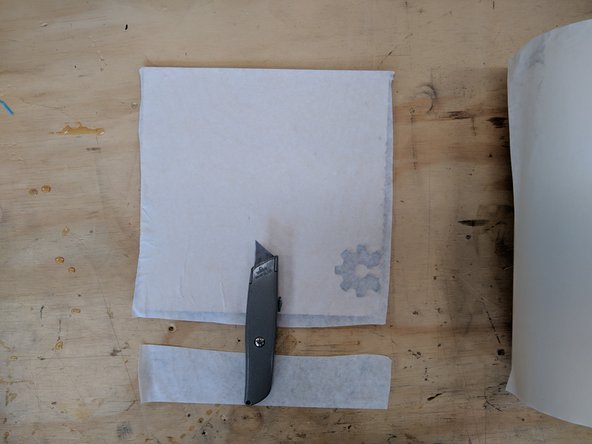 Locate the 12&quot; roll of masking tape at the Infrared Camera work station.  Peel off several inches of this tape from the roll but do not yet cut it off.  Begin by aligning the top left corner of this strip with the top left corner of your material.  Make sure the top edge of the tape is parallel with the top edge of your material.