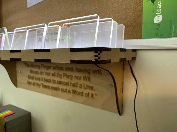 The cut out circle is there to run the cord of the 12 V wall wart through and should be in the back right part of the shelf, where the brackets attach.   Run the wire from the wall wart through this hole and secure the wire so it won't pull out.
