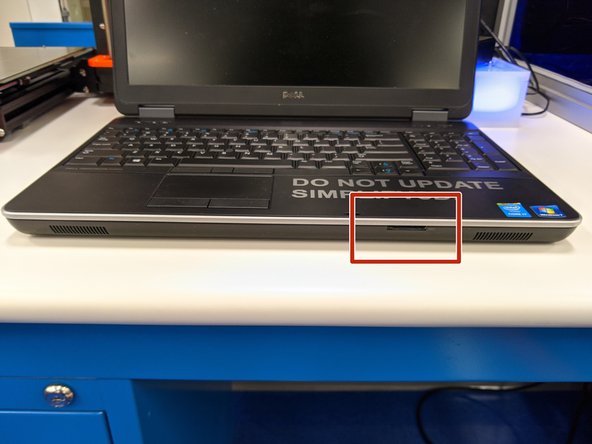 Insert the SD into the card reader located on the front of the laptop.