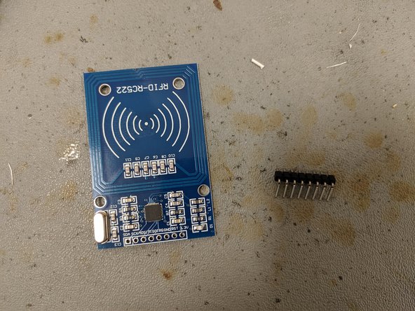 Solder a 90-degree 8-pin header onto the top of the RFID card reader.  The short pins are soldered into the board and the longer pins should be parallel to the plane of the RFID board as shown.