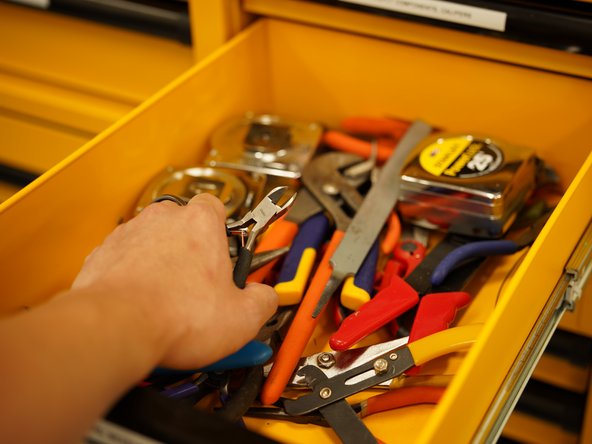 Locate the yellow Dewalt cabin and find a pair of pliers.